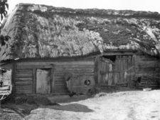 A post-and-plank barn with a cowshed